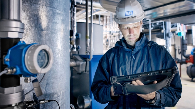 Man standing in plant with tablet checking the digital assets