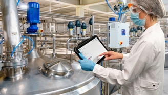 Woman standing in production facility and checking the Netilion Asset Health status